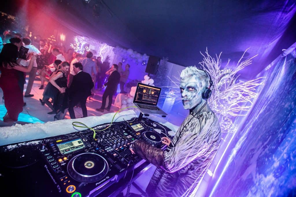 a man dressed as a White Walker from Game of Thrones, wearing headphones and using a dj mixer. Inspiring marquee pictures